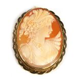 A 9ct gold framed shell cameo brooch, the cameo depicting maiden in flowing dress, with a double bea