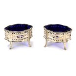 A pair of George V silver salts, of serpentine form, with pierced and engraved decoration, with blue