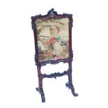 A 19thC rosewood fire screen, the surround carved with scrolls, foliate motifs, etc, on scroll legs,