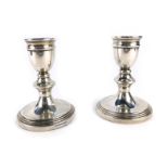 A pair of George V silver dwarf candlesticks, each on a ribbed base, weighted, Birmingham 2009, 15.9