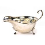 A George V silver sauce boat, with a fluted border on tripod ball and claw feet, Birmingham 1929, 3.