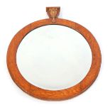 An early 20thC oak wall mirror, the top surmounted by a carved crest, above a circular mirror, a cen