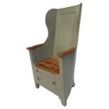 A reproduction French painted pine lambing chair, with a solid back and seat, cupboard to base, on b
