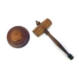 An oak gavel, with tuned wooden handle, 27cm long, together with an oak stepped base, 12cm diameter.