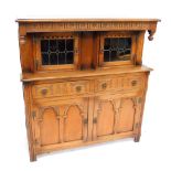 A carved oak court cupboard, with a low moulded top, above two astragal glazed doors, with two drawe