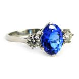 A sapphire and diamond cluster ring, the central oval sapphire in six claw setting, 9.6mm x 7.8mm x