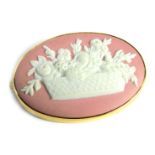 A Wedgwood pink jasperware basket weave oval brooch, in a plated outer border, 3.5cm diameter, 8.4g