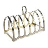 A George V silver six division toast rack, of arched form with ring handle, Birmingham 1931, 12cm wi