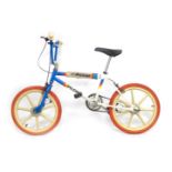 A Raleigh BMX bike, with blue and white striped frame and red wheels.