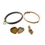 A group of jewellery, comprising a rolled gold bangle, an imp pendant, rolled gold heart shaped pend