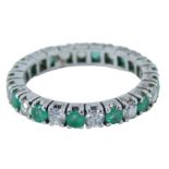 An emerald and diamond set eternity ring, round brilliant cut stones each in claw setting, on a whit