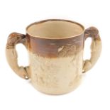 An early 20thC Doulton stoneware loving cup, in brown treacle glaze with greyhound handles, 14cm hig