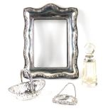 A silver photograph frame, silver gin decanter label, miniature silver basket, and a cut glass and s