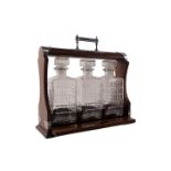 An oak tantalus, with chrome painted mounts and three moulded glass decanters, 38cm wide.