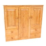 A pine cupboard, with an arrangement of single column with door and two drawers, and a double sectio