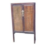 A Chinese hardwood cabinet, with two panelled doors, brass lock, etc., 149cm high, 83cm wide. (AF)