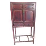 A Chinese red elm cabinet, with two panelled doors above two drawers, above a lattice under tier, 16