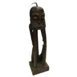 Tribal art. A carved figure of a face held in hands, with notch recesses for CDs and applied hair, 1