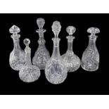 A collection of cut glass decanters and various stoppers.