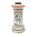 A Chinese famille verte porcelain oil lamp base, decorated with birds, leaves, and figures beside bu