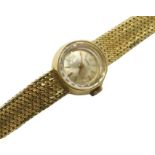 A Zodiac 18ct gold wristwatch, with a small silvered numeric dial, 1cm wide, on a 9ct gold bracelet,