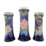 Three Royal Doulton stoneware vases, of matching design on a blue and purple ground comprising a pai