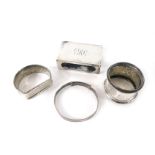 A group of silver wares, comprising a silver match case and three silver napkin rings, 2.08oz.