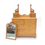 A Victorian satin walnut dressing chest, the top with four frieze drawers and an arched mirror, on c