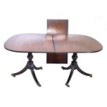 A twin pillar mahogany D end extending dining table, with one leaf, on turned legs terminating in br