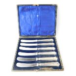 A set of six silver handled butter knives.