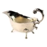 A George V silver sauce boat, with fluted border and camphor leaf handle, on shell tripod feet, Birm