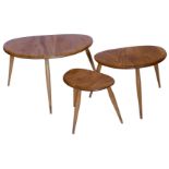 A nest of three Ercol elm and beech pebble shaped tables, lacking labels, the largest 64cm wide.