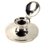 A George V silver capstan inkwell, of plain design with clear glass inkwell, on an ebony base, Chest