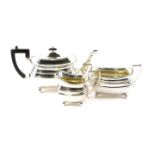 A George V silver three piece tea set, with gadrooned borders, the teapot with ebonised handle and k