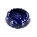 A Royal Doulton stoneware ash tray, the shaped outer dark blue glazed tray with tulips, numbered 971