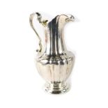An early Victorian silver cream jug, with a fluted handle, and engraved and embossed floral body, ma