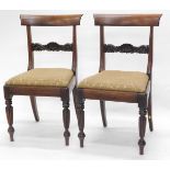 A pair of William IV mahogany dining chairs, each with a drop in seat, on turned reeded legs.