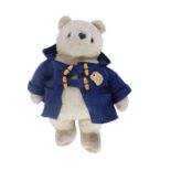 A 20thC plush jointed Teddy bear, wearing blue duffel coat with material pads, 44cm high.