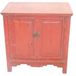 A Chinese red painted side cabinet, with two panelled doors, on stiles with shaped apron, 76cm high,