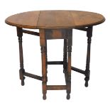 A small oak drop leaf table, the oval top with a moulded edge, on turned supports, 60cm wide.