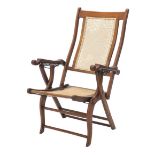 A late 19thC walnut folding steamer chair, with caned back and seat, shaped arms, on X shaped suppor
