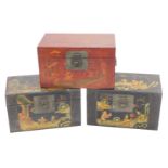 Three various Chinese small canvas boxes or trunks, two decorated with children and figures, on a bl