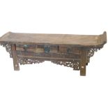 A Chinese low table or bench, with raised sides above three frieze drawers and a carved frieze, on c
