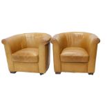 A pair of Multi York tan leather club chairs.