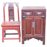 A Chinese red and brown stained side cabinet, with two drawers above two panelled doors, on stiles w