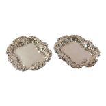 A pair of George V white metal pin dishes, each with a fluted floral outer border and vacant cartouc