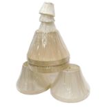 A collection of Chinese cream fabric covered lamp shades, various sizes.