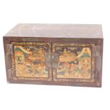 A Chinese red lacquer cabinet, the doors decorated with figures, buildings within landscapes, etc.,