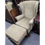 A Parker Knoll green floral seated armchair and matching footstool.