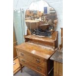 An oak dressing table, with shaped mirrored back, on arrangement of two drawers terminating in stile